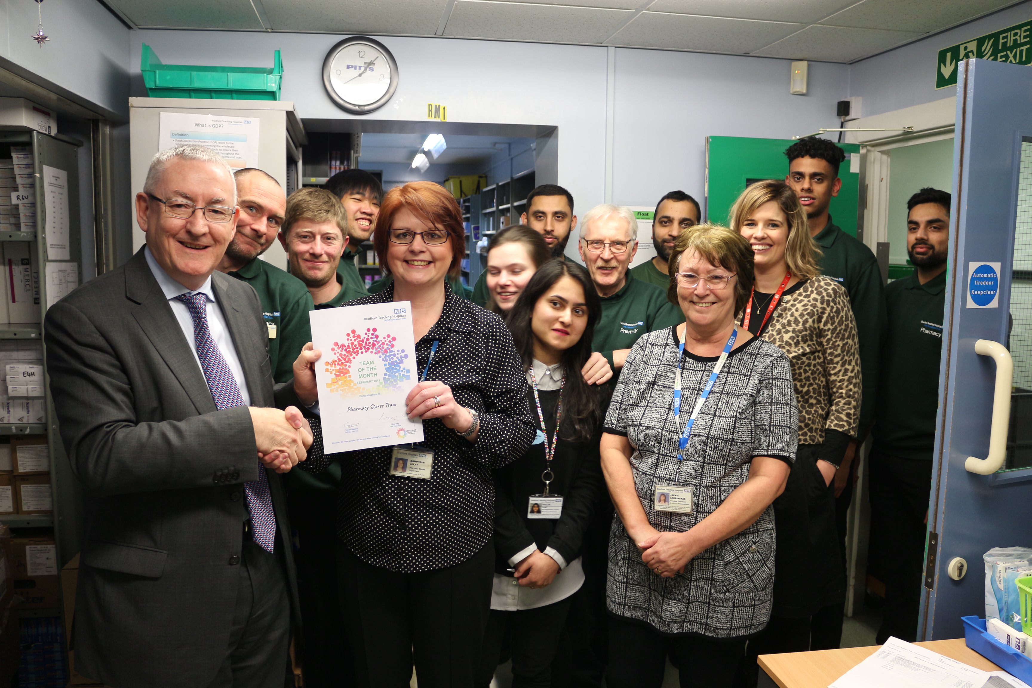 Chief Medical Officer Dr Bryan Gill presents the Team of the Month award to the Pharmacy Stores team.