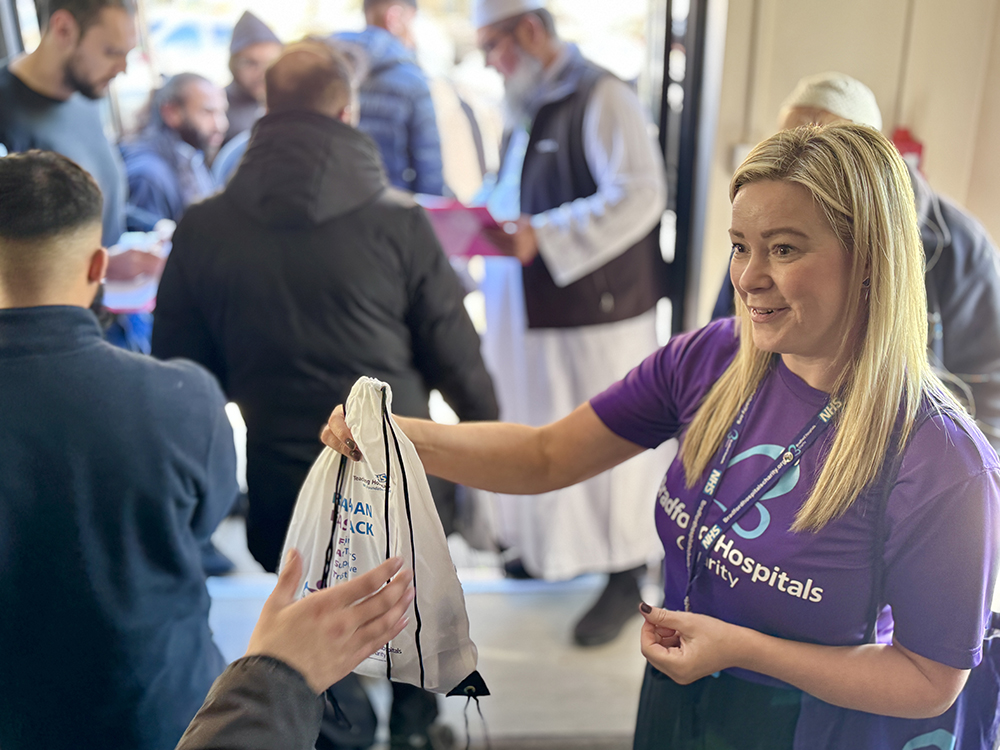 IMG_9785 - SM Charity team member handing out a FAST pack bag in the Muslim prayer facility.