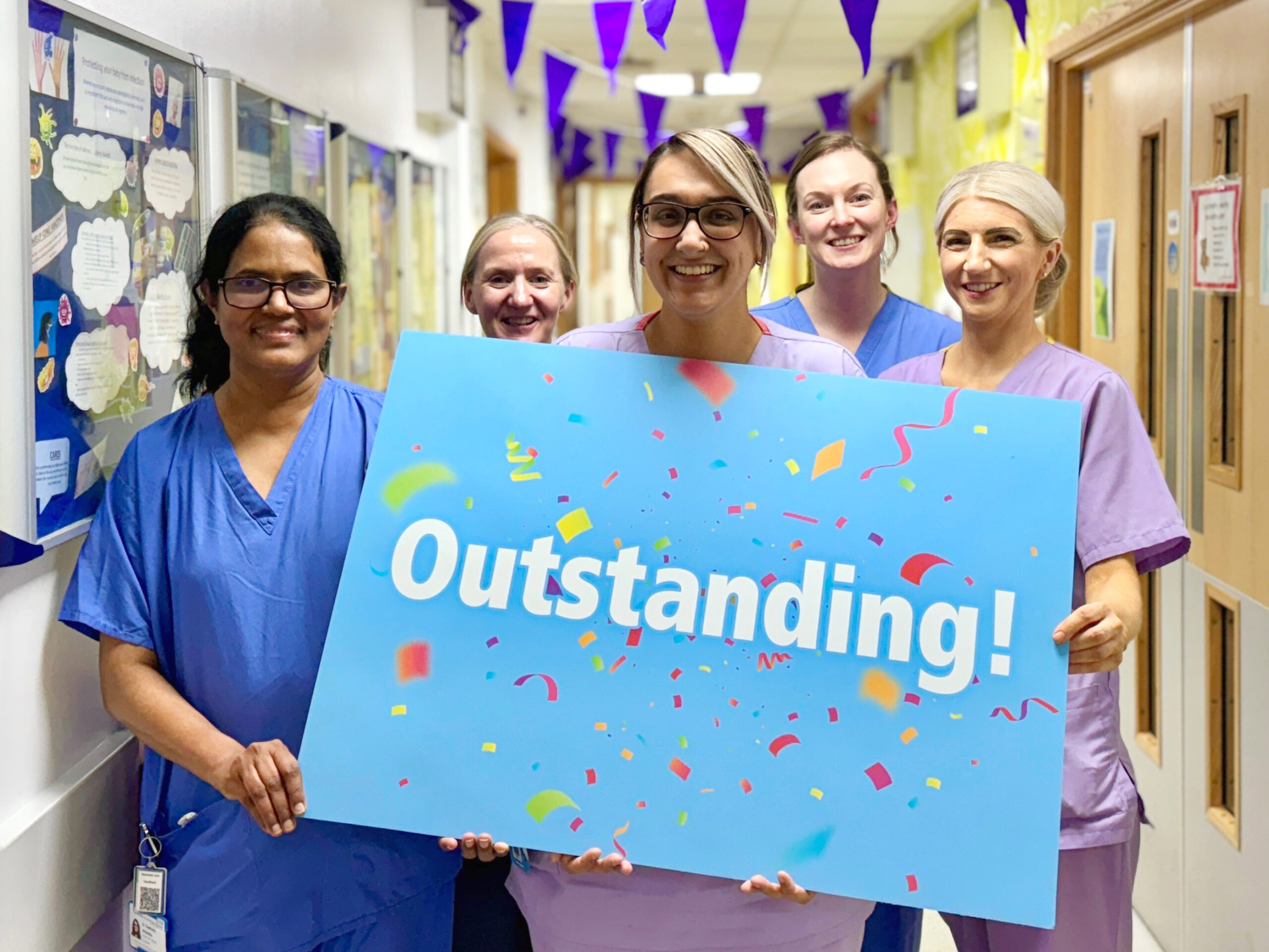 Neonatal - team pic - outstanding Five members of the Neonatal team holding an Outstanding sign.