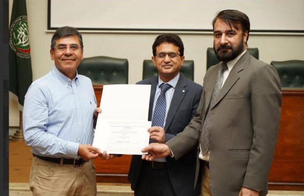 Prof Khan being presented with his professorship in Pakistan