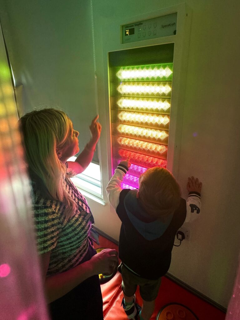An adult and a child looking at the sensory light device