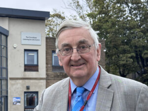 Professor Chris Raine in front of the Listening for Life Centre which has been renamed in his honour.