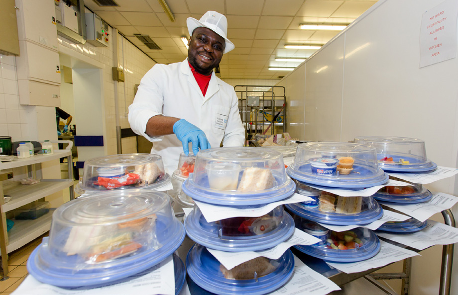hospital catering worker preparing and packaging meals