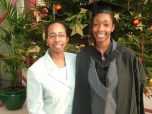 Mum and daughter (in gown with mortarboard) smile to the camera on Emma's graduation day as a nurse